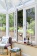 White tilt and turn casement window opening onto garden from conservatory from the Anglian tilt and turn window range