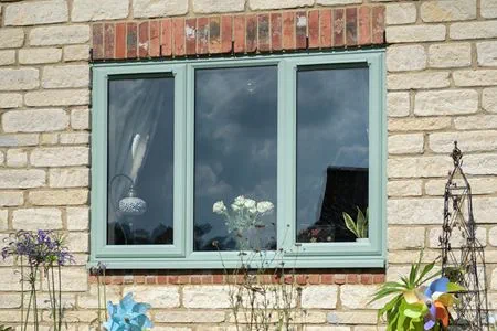 Closed uPVC sage green casement window viewed from outside cropped