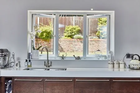 Open white uPVC kitchen windows with gold effect handles Opening outwards