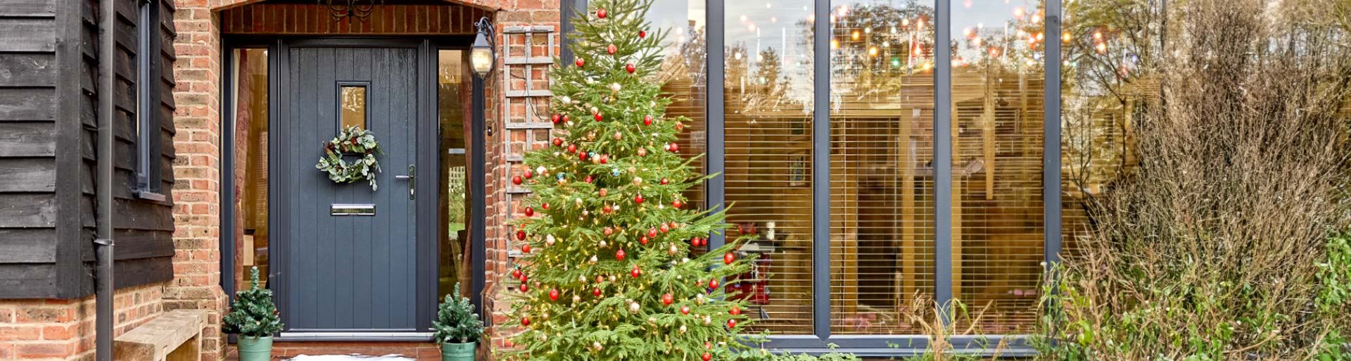 Doors winter banner with a festive tree and wreath on the door