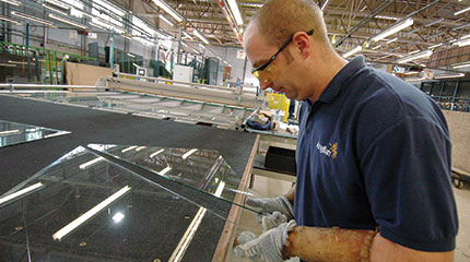 Male worker assembling conservatory glass at Anglian Home Improvements manufacturing facility