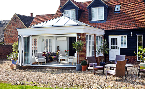 Large white orangery with bifold doors and timber casement windows from the Anglian orangery range