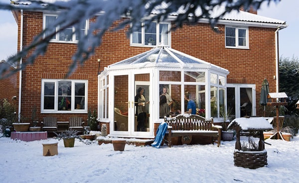 Large white uPVC Elizabethan conservatory with French doors in the snow